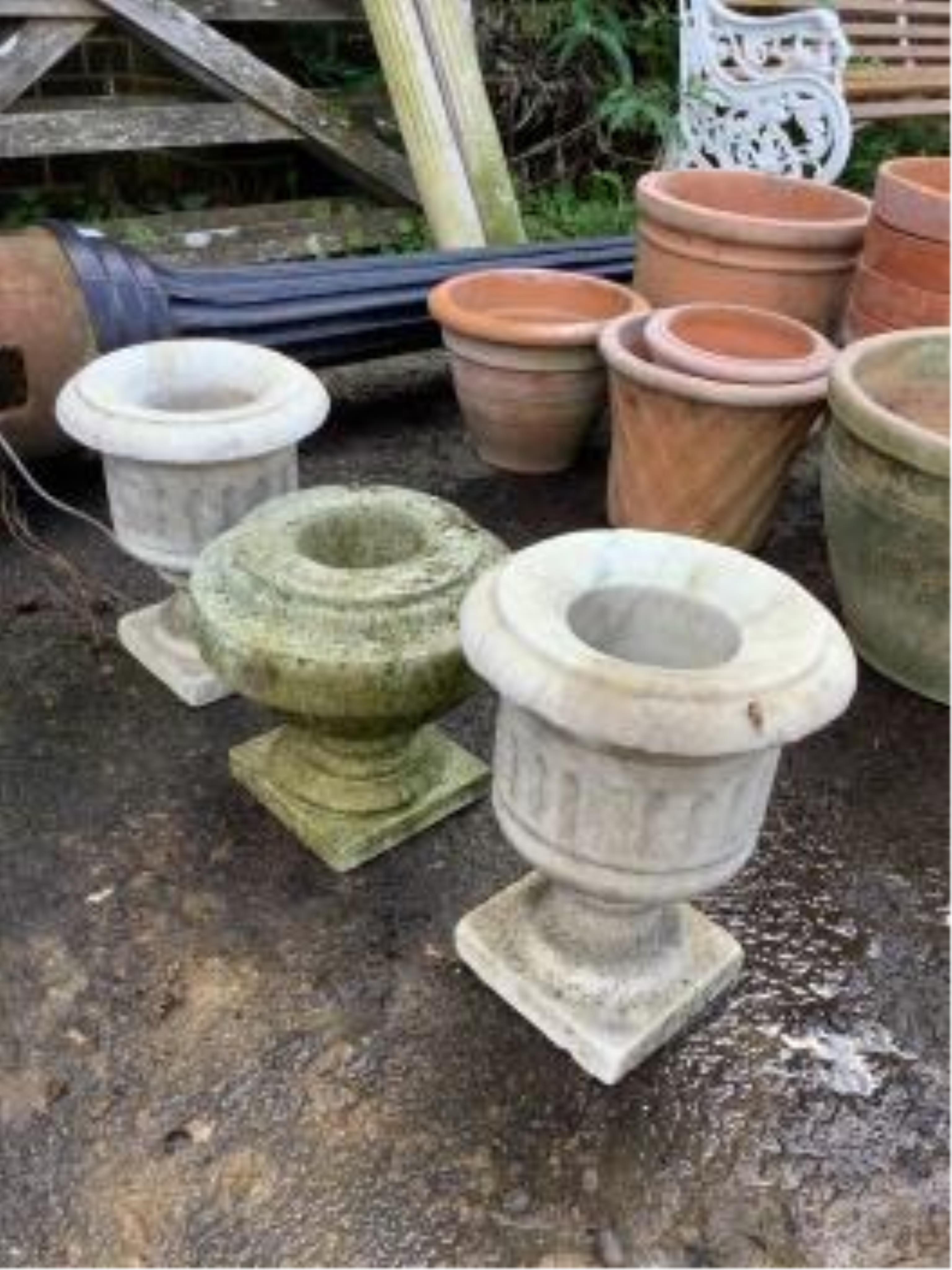 A pair of reconstituted stone garden urns, height 55cm and three assorted marble urns. Condition - all weathered